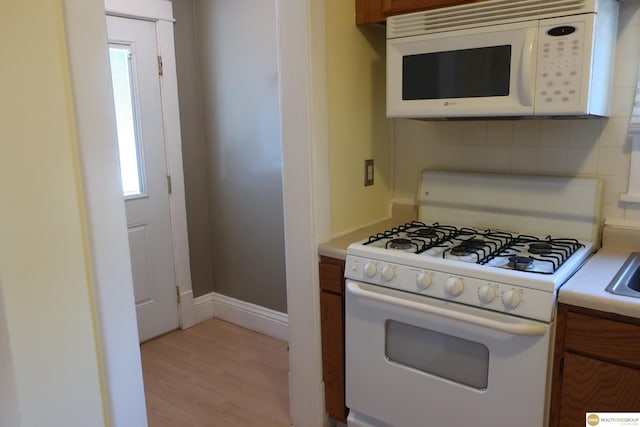 2722 N 64th St, Omaha, NE 68104 - kitchen featuring white appliances, brown cabinets, tasteful backsplash, and light countertops