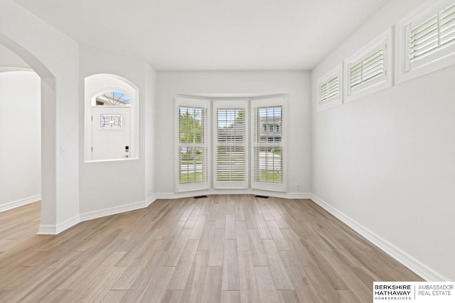 20155 Farnam St, Elkhorn, NE 68022 - empty room featuring light wood finished floors, arched walkways, and baseboards