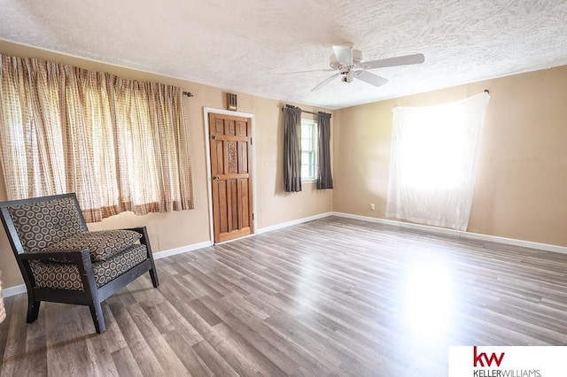 90 N Montgomery St, Nelson, NE 68961 - sitting room with a ceiling fan, wood finished floors, baseboards, and a textured ceiling