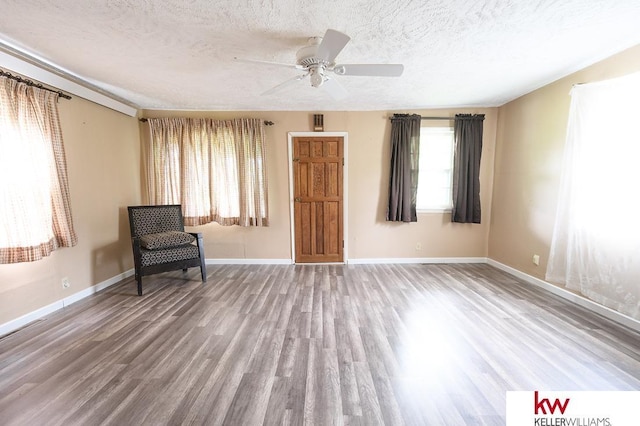 90 N Montgomery St, Nelson, NE 68961 - sitting room with wood finished floors, a ceiling fan, a textured ceiling, and baseboards
