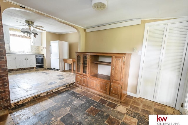 90 N Montgomery St, Nelson, NE 68961 - kitchen with freestanding refrigerator, arched walkways, ceiling fan, a sink, and crown molding