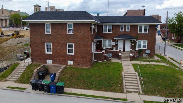 818 S 26th St, Omaha, NE 68105 - townhome / multi-family property with brick siding, stairway, a front yard, and a chimney
