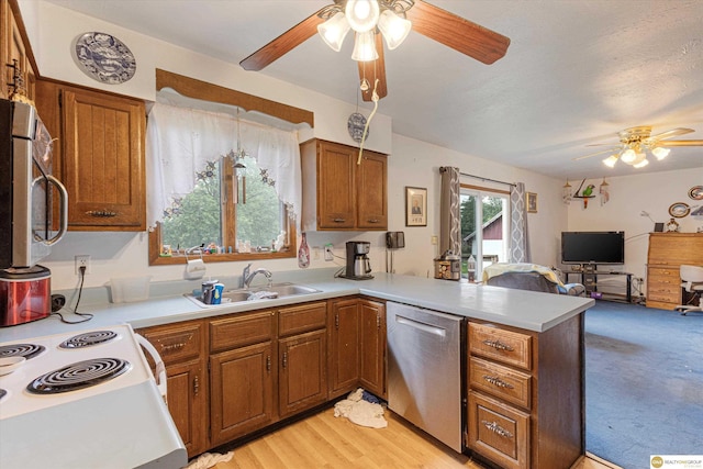 209 Carter St, Avoca, NE 68307 - kitchen with stainless steel appliances, ceiling fan, a peninsula, and brown cabinetry