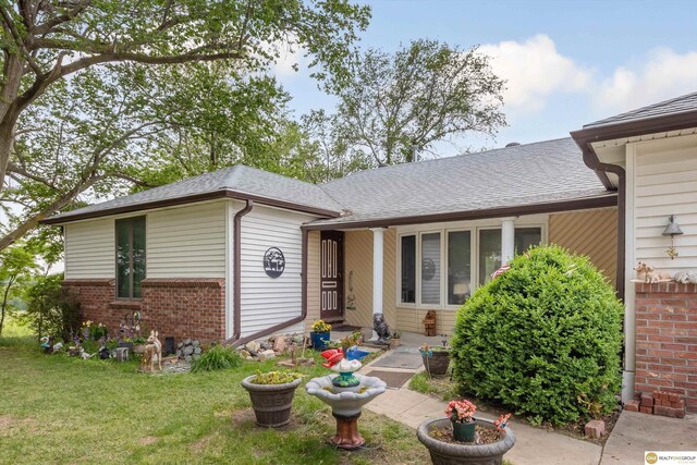 209 Carter St, Avoca, NE 68307 - ranch-style home featuring brick siding, a front yard, and a shingled roof