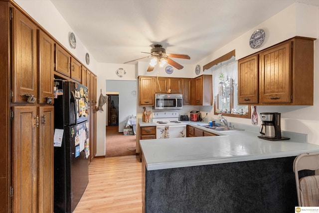 209 Carter St, Avoca, NE 68307 - kitchen with white electric range, freestanding refrigerator, stainless steel microwave, a peninsula, and light wood-style floors