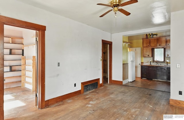 1822 N 38th St, Omaha, NE 68111 - unfurnished living room featuring ceiling fan, hardwood / wood-style flooring, and baseboards