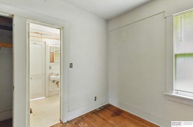 1822 N 38th St, Omaha, NE 68111 - unfurnished bedroom with wood finished floors, ensuite bath, and a sink
