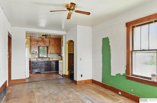 1822 N 38th St, Omaha, NE 68111 - unfurnished living room featuring arched walkways, a ceiling fan, wood-type flooring, and a sink