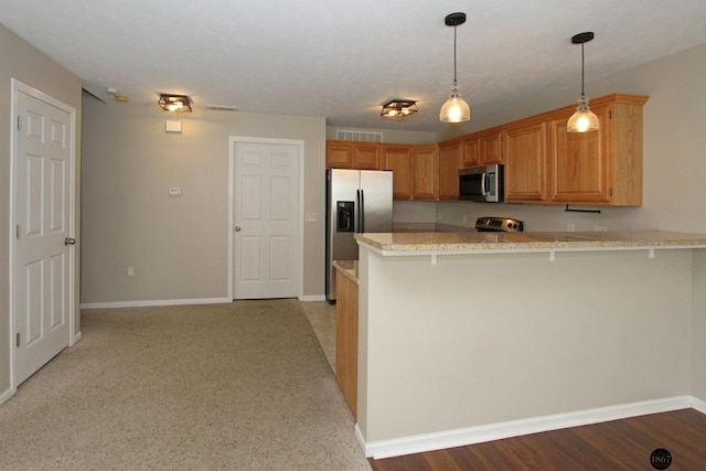 6028 Glenbrook Ln, Lincoln, NE 68512 - kitchen featuring stainless steel appliances, a peninsula, baseboards, light stone countertops, and a breakfast bar