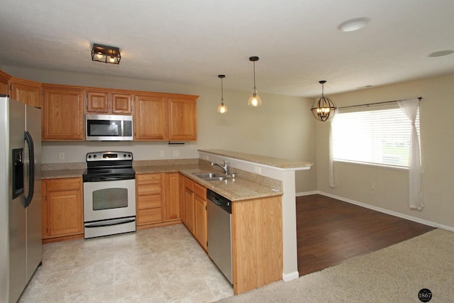 6028 Glenbrook Ln, Lincoln, NE 68512 - kitchen featuring appliances with stainless steel finishes, a sink, a peninsula, pendant lighting, and baseboards