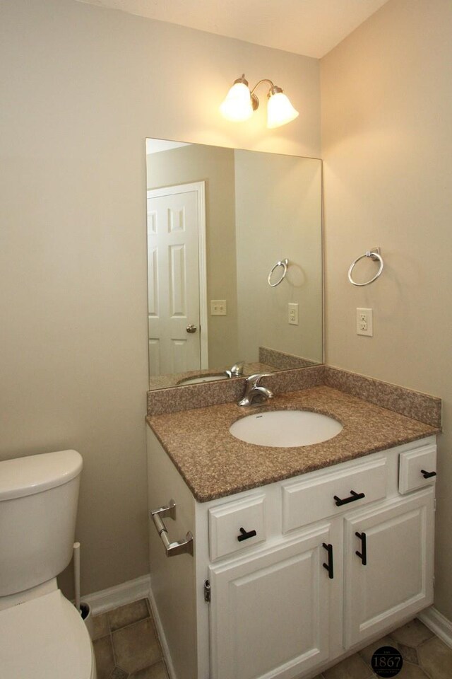 6028 Glenbrook Ln, Lincoln, NE 68512 - bathroom with toilet, vanity, baseboards, and tile patterned floors