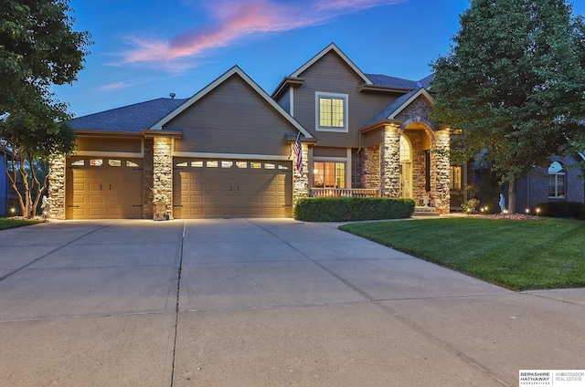 6111 S 194th Ave, Omaha, NE 68135 - view of front of house with stone siding, a lawn, an attached garage, and driveway