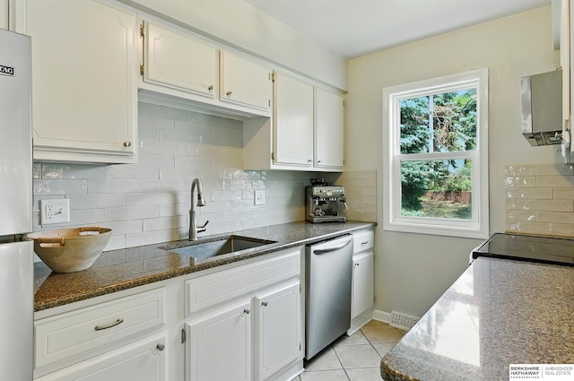9704 Erskine St, Omaha, NE 68134 - kitchen featuring stainless steel dishwasher, dark stone countertops, decorative backsplash, white cabinetry, and light tile patterned floors