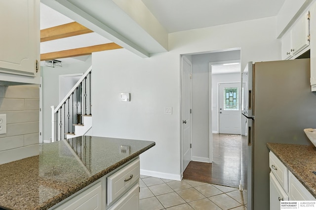 9704 Erskine St, Omaha, NE 68134 - kitchen featuring freestanding refrigerator, light tile patterned flooring, dark stone counters, and white cabinetry