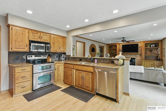 2468 N 148th St, Omaha, NE 68116 - kitchen with stainless steel appliances, a sink, open floor plan, ceiling fan, and a peninsula