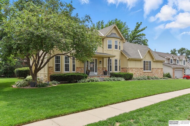 2468 N 148th St, Omaha, NE 68116 - view of front of house featuring brick siding, a front lawn, stucco siding, and board and batten siding