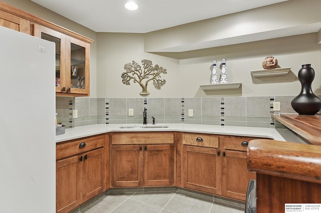 2468 N 148th St, Omaha, NE 68116 - kitchen with a sink, freestanding refrigerator, brown cabinetry, light countertops, and backsplash