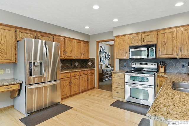 2468 N 148th St, Omaha, NE 68116 - kitchen with appliances with stainless steel finishes, light wood-style flooring, decorative backsplash, recessed lighting, and brown cabinets