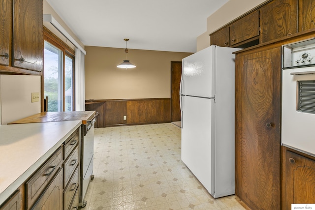 3809 N 94th St, Omaha, NE 68134 - kitchen with white appliances, light floors, wainscoting, light countertops, and hanging light fixtures