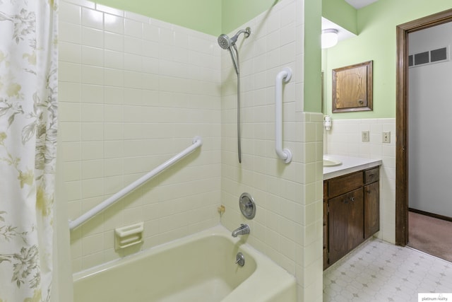 3809 N 94th St, Omaha, NE 68134 - full bath with shower / bath combo, tile patterned floors, vanity, a wainscoted wall, and tile walls