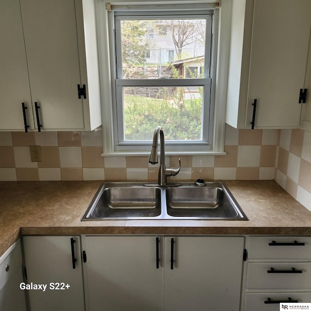2134 S 48th St, Omaha, NE 68106 - kitchen with a sink, white cabinetry, plenty of natural light, and decorative backsplash