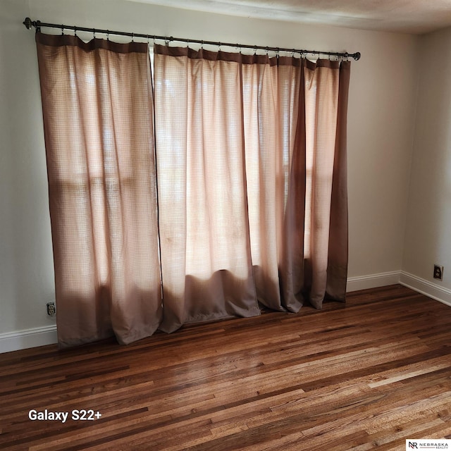 2134 S 48th St, Omaha, NE 68106 - empty room featuring baseboards, dark wood finished floors, and plenty of natural light