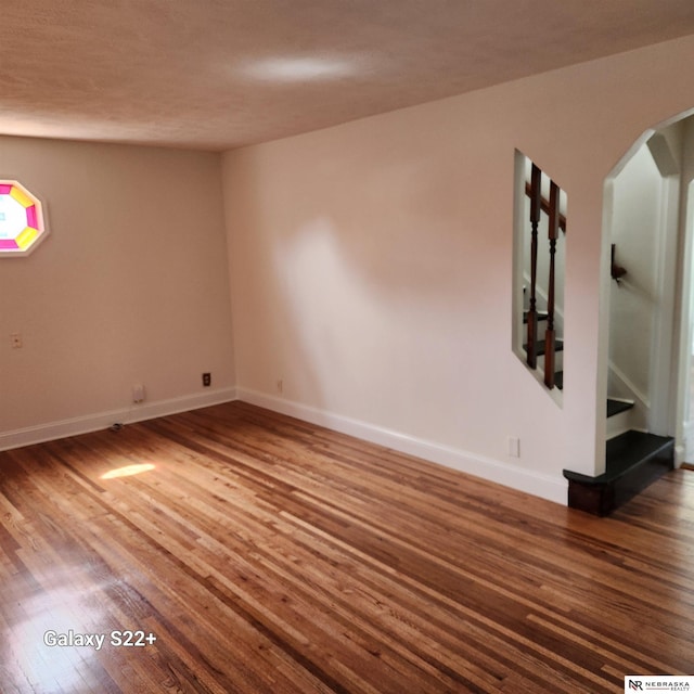 2134 S 48th St, Omaha, NE 68106 - unfurnished room featuring wood finished floors, arched walkways, and baseboards