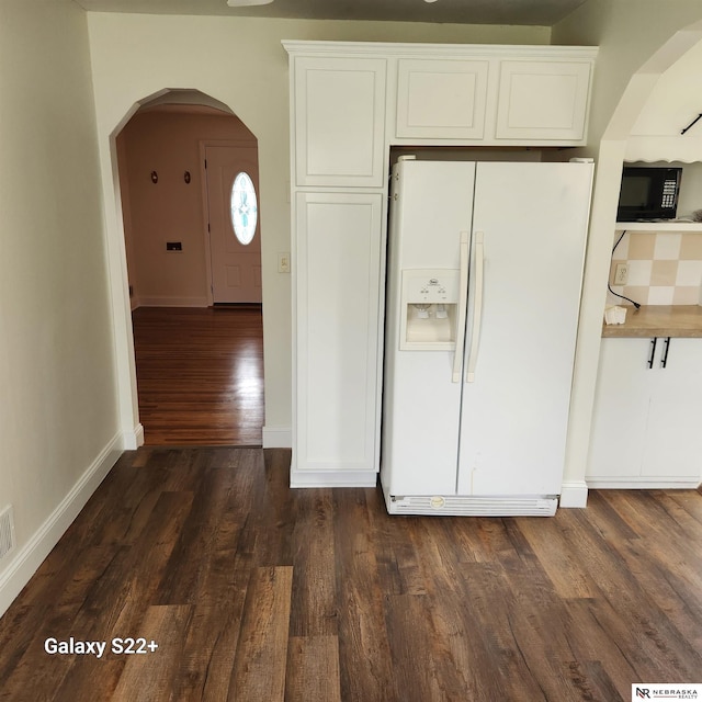 2134 S 48th St, Omaha, NE 68106 - kitchen featuring white refrigerator with ice dispenser, black microwave, arched walkways, dark wood finished floors, and white cabinets