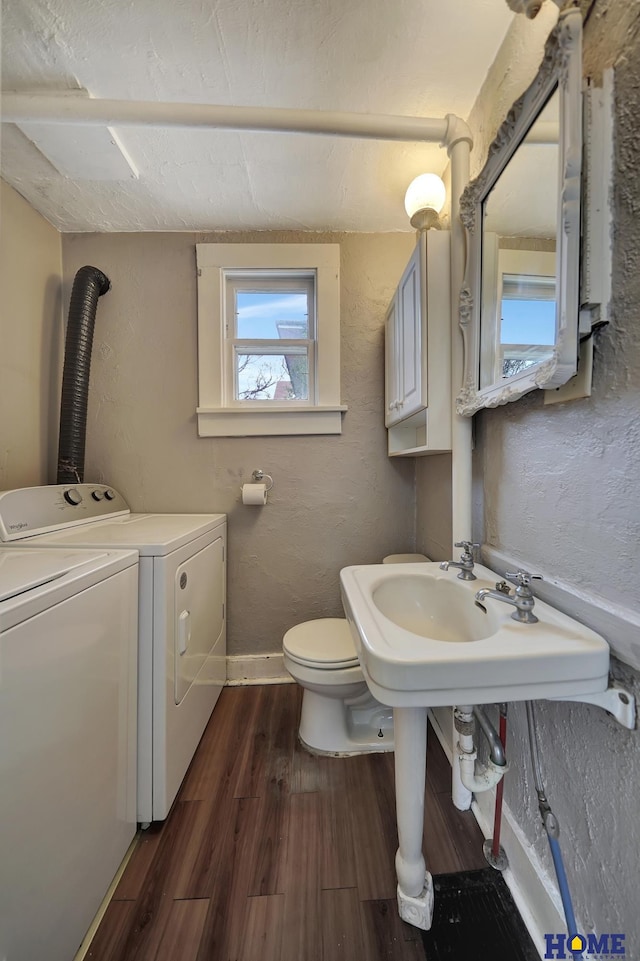 2524 S St, Lincoln, NE 68503 - half bathroom featuring separate washer and dryer, wood finished floors, toilet, and baseboards