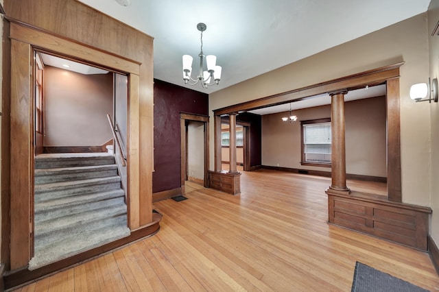 2524 S St, Lincoln, NE 68503 - unfurnished room featuring a chandelier, light wood-type flooring, baseboards, and stairs
