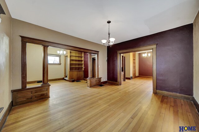2524 S St, Lincoln, NE 68503 - empty room featuring a chandelier, baseboards, and light wood-style flooring