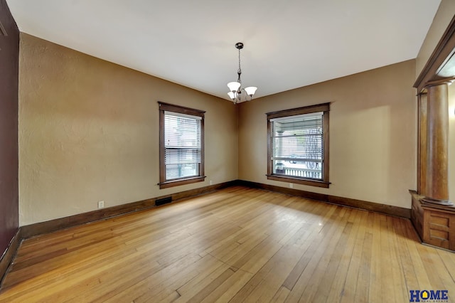 2524 S St, Lincoln, NE 68503 - unfurnished room with plenty of natural light, light wood-type flooring, a chandelier, and baseboards