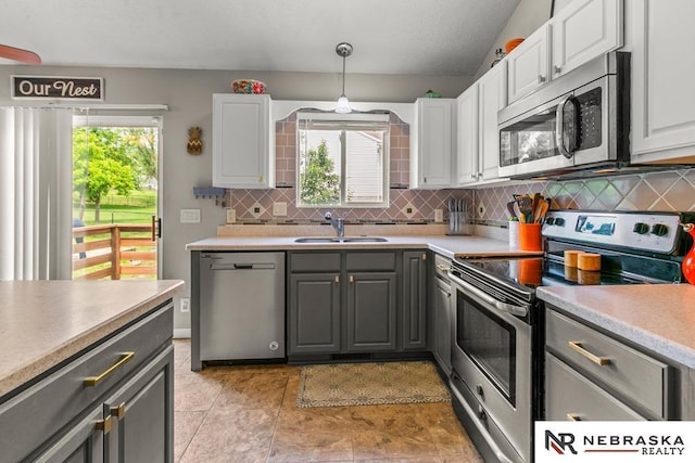 13518 Westport Cir, Bellevue, NE 68123 - kitchen featuring appliances with stainless steel finishes, a sink, gray cabinetry, backsplash, and light countertops