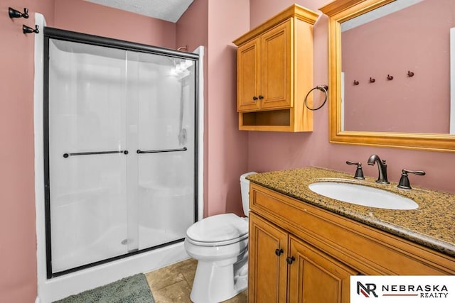 13518 Westport Cir, Bellevue, NE 68123 - bathroom with a shower stall, vanity, toilet, and tile patterned flooring