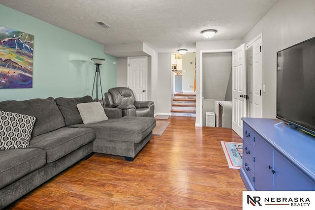 13518 Westport Cir, Bellevue, NE 68123 - living room with light wood finished floors, a textured ceiling, stairway, and baseboards