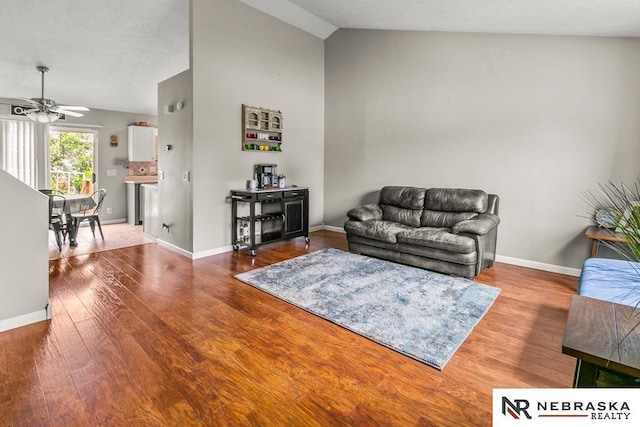 13518 Westport Cir, Bellevue, NE 68123 - living room featuring vaulted ceiling, ceiling fan, wood finished floors, and baseboards