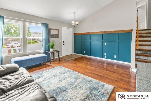 13518 Westport Cir, Bellevue, NE 68123 - living room with stairs, wood finished floors, a chandelier, vaulted ceiling, and a decorative wall