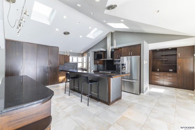 10615 Martha St, Omaha, NE 68124 - kitchen featuring a skylight, appliances with stainless steel finishes, dark countertops, a kitchen bar, and lofted ceiling