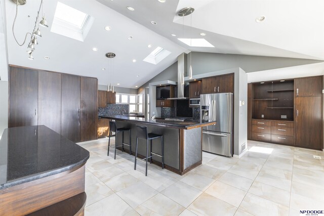 10615 Martha St, Omaha, NE 68124 - kitchen featuring a skylight, appliances with stainless steel finishes, dark countertops, a kitchen bar, and lofted ceiling