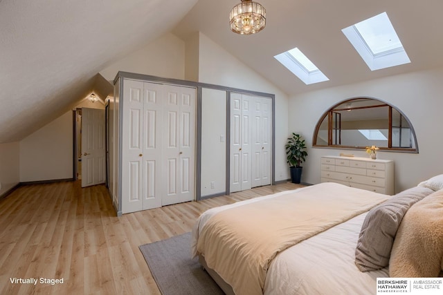 4459 F St, Omaha, NE 68107 - bedroom featuring a skylight, lofted ceiling, two closets, light wood-type flooring, and baseboards