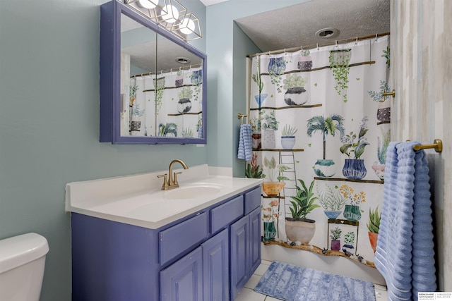 4459 F St, Omaha, NE 68107 - full bath featuring toilet, vanity, tile patterned flooring, a textured ceiling, and a shower with shower curtain