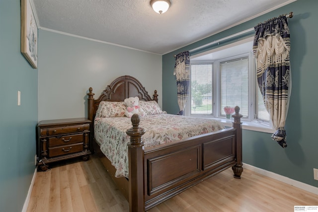 4459 F St, Omaha, NE 68107 - bedroom featuring light wood-style floors, a textured ceiling, ornamental molding, and baseboards