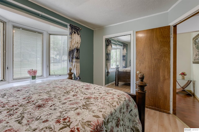 4459 F St, Omaha, NE 68107 - bedroom with light wood-style flooring, ornamental molding, and a textured ceiling