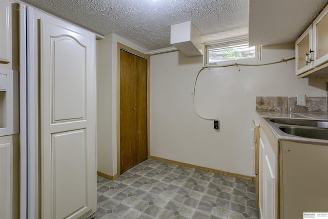 4459 F St, Omaha, NE 68107 - laundry area featuring a textured ceiling and baseboards