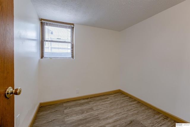 4459 F St, Omaha, NE 68107 - unfurnished room featuring wood finished floors, baseboards, and a textured ceiling