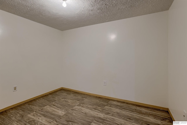 4459 F St, Omaha, NE 68107 - spare room featuring wood finished floors, a textured ceiling, and baseboards