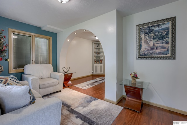 4459 F St, Omaha, NE 68107 - living room featuring wood finished floors, arched walkways, baseboards, and built in features