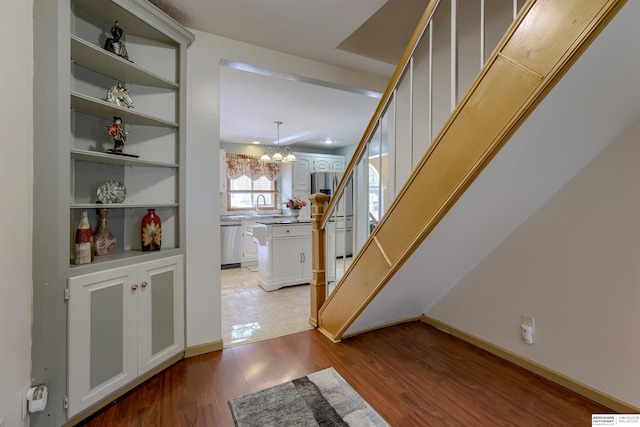 4459 F St, Omaha, NE 68107 - entrance foyer featuring stairs, light wood-style flooring, a chandelier, and baseboards
