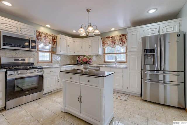 4459 F St, Omaha, NE 68107 - kitchen featuring stainless steel appliances, a sink, white cabinetry, a chandelier, and recessed lighting