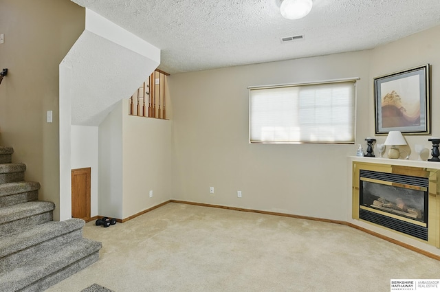 8853 N 82nd Ave, Omaha, NE 68122 - unfurnished living room featuring carpet floors, stairway, a glass covered fireplace, a textured ceiling, and baseboards